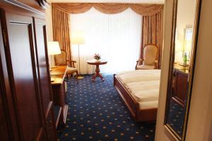 a hotel room with a bed and a table at Hotel König-Stuben in Bispingen +20 photos