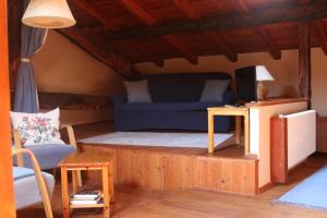 a living room with a blue couch and a table at Locanda Dei Gelsi in Villar San Costanzo