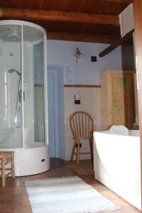 a bathroom with a glass shower and a wooden chair at Locanda Dei Gelsi in Villar San Costanzo