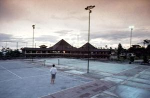 峇圖拉登的住宿－皇后花園酒店，一个人站在网球场上