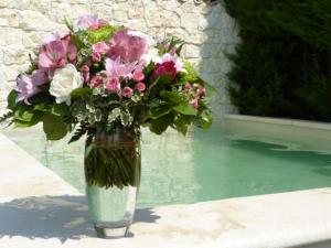 een vaas gevuld met bloemen zittend op een tafel bij Chambre d'hotes Casa Biba in Vence
