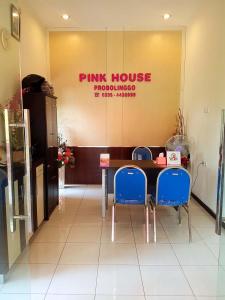 um restaurante rosa com uma mesa e cadeiras azuis em Pink House em Probolinggo