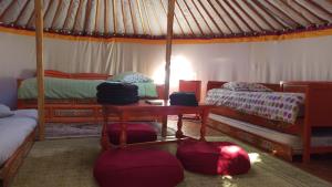 - une chambre avec 2 lits et une table dans une tente dans l'établissement Aux Yourtes de La Fabrique, à Saint-Florent-des-Bois