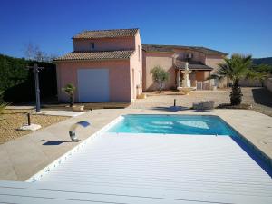 a swimming pool in front of a house at Les Gites de Kevinou in Vallon-Pont-dʼArc