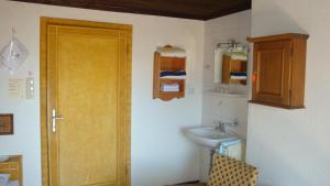 a bathroom with a wooden door and a sink at Berghotel Blaickner's Sonnalm in Zell am See