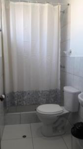 a bathroom with a toilet and a shower curtain at Suite Trujillo in Trujillo