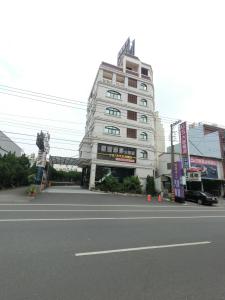 a large white building on the side of a street at 雲林斗六福爾摩莎大飯店 in Douliu