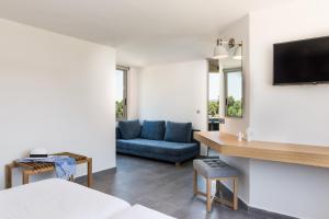 Una sala de estar con un sofá azul y un televisor. en Stellina Village, en Kato Daratso