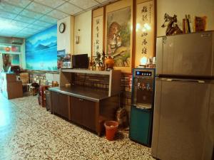 a kitchen with a refrigerator and a counter in a room at Sun Moon Lake Fisherman Homestay in Yuchi