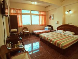 a bedroom with a bed and a chair and a window at Sun Moon Lake Fisherman Homestay in Yuchi
