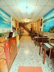- un restaurant avec des tables et des chaises en bois dans une chambre dans l'établissement Sun Moon Lake Fisherman Homestay, à Yuchi