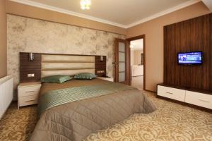 a bedroom with a large bed and a flat screen tv at Balturk House Hotel in Kocaeli