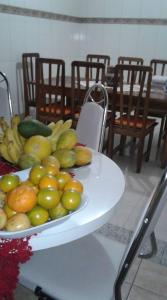 un plato de fruta en una mesa con sillas en Santa Helena Pousada, en Cachoeira Paulista