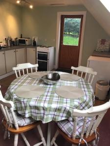a kitchen with a table with four chairs and a table and a window at Whitehill in Finzean