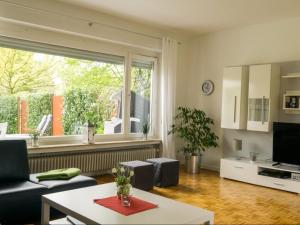 uma sala de estar com um sofá e uma grande janela em Dat Ferienhus em Bad Zwischenahn