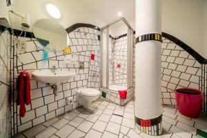 a bathroom with a sink, toilet, and bathtub at artHOTEL Magdeburg in Magdeburg