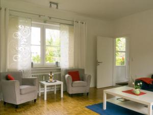 a living room with two chairs and a table at Dat Ferienhus in Bad Zwischenahn