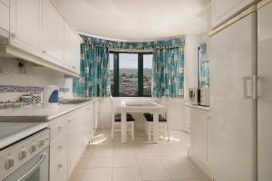 a white kitchen with a table and a window at Apartment Bay Historic Center in Funchal