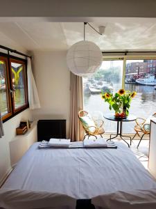 Dormitorio con cama y vistas al agua en Houseboat Concordia B&B en Ámsterdam
