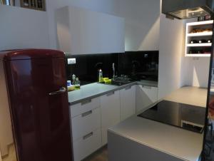 cocina con nevera negra y armarios blancos en Apartment Andrija, en Baška Voda