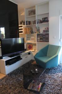 sala de estar con TV y silla azul en Apartment Andrija, en Baška Voda