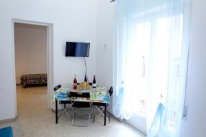 トラーパニにあるL'ANGOLO DI SAN MICHELEのテーブル(ワインボトル付)が備わる客室です。