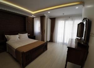 1 dormitorio con 1 cama grande y TV en Taksim Flat, en Estambul