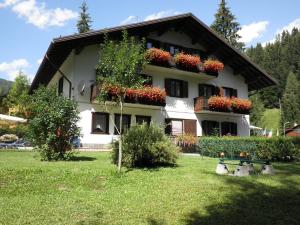 una casa con cajas de flores a un lado. en Appartamenti Nigritella, en Falcade