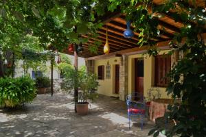 a courtyard of a house with a table and chairs at Chouchounikos Apartments in Lefokastro