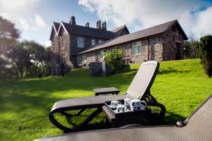a chair with a table in front of a house at Penrhiw Priory in St. Davids