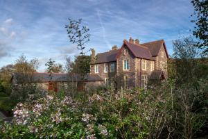 a large brick house with flowers in front of it at Penrhiw Priory in St. Davids