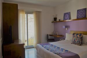 a bedroom with a bed and a tv and a window at Mine Hotel in Buenos Aires