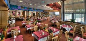 ein leeres Restaurant mit rosa Tischen und Stühlen in der Unterkunft Hotel Ajda Depandance Prekmurska Vas - Terme 3000 - Sava Hotels & Resorts in Moravske-Toplice