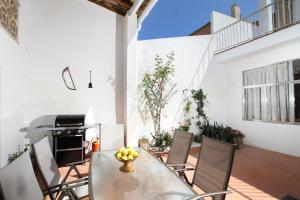 a patio with a table and chairs and a grill at Ca'n Claret in Llucmajor