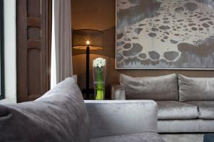 a living room with a couch and a table with a lamp at Penrhiw Priory in St. Davids
