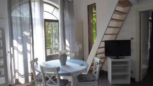 uma sala de jantar branca com uma mesa e uma televisão em Il Liberty di Emilia em Mondello