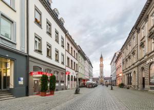 an empty city street with buildings and a clock tower at City Hotel Konstanz in Konstanz