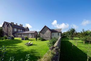 a large house with a grass yard in front of it at Penrhiw Priory in St. Davids