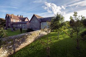 an image of a house with a stone wall at Penrhiw Priory in St. Davids