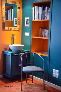 baño con lavabo, silla y libros en Chez Catie en Quintin