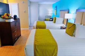 a hotel room with two beds and a tv at Silver Palms Inn in Key West