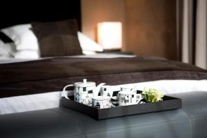 a tray with cups and plants on a bed at Penrhiw Priory in St. Davids
