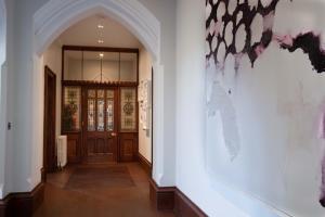 a hallway with a door and a painting on the wall at Penrhiw Priory in St. Davids