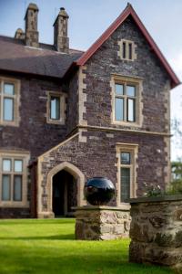 a large brick house with a black bowl in front of it at Penrhiw Priory in St. Davids