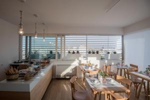 レッチェにあるB&B Il Palazzotto Luxury Suitesのテーブルと椅子、大きな窓のあるレストラン