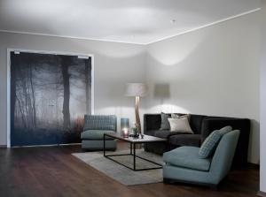 a living room with a couch and a table and chairs at Soria Moria Hotell in Oslo