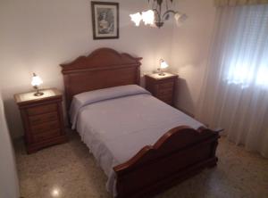 コニル・デ・ラ・フロンテーラにあるApartamento Villamartínのベッドルーム1室(木製ベッド1台、ナイトスタンド2台付)