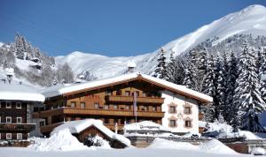 a ski lodge in the snow with snow covered trees at Hotel Glockenstuhl in Gerlos