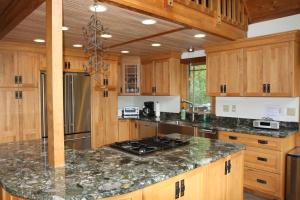 eine Küche mit Holzschränken und einer Granitarbeitsplatte in der Unterkunft Cedarwalk in Killington