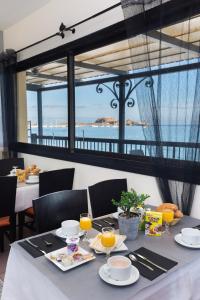 a dining table with a view of the ocean at Joseph Charles in LʼÎle-Rousse